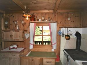 cocina con paredes de madera y ventana en Chalet Chalet Antritt by Interhome, en Schmirn