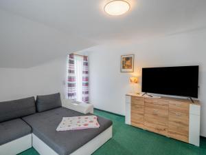 a living room with a couch and a flat screen tv at Apartment Haus Toferer by Interhome in Grossarl