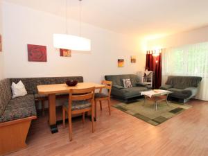 ein Wohnzimmer mit einem Tisch und einem Sofa in der Unterkunft Apartment Am Birkenhain-17 by Interhome in Seefeld in Tirol