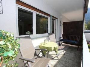 een patio met een tafel en stoelen op een balkon bij Apartment Am Birkenhain-28 by Interhome in Seefeld in Tirol