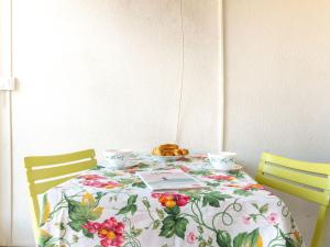 ラカノー・オセアンにあるApartment Les Sables d'Argent-5 by Interhomeの花のテーブルクロスと椅子2脚付きのテーブル