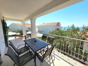 Un porche con una mesa y sillas en un balcón. en Apartment Katarina 5 by Interhome, en Brodarica