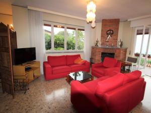 ポルト・ヴァルトラヴァーリアにあるHoliday Home Bramati by Interhomeのリビングルーム(赤い家具、暖炉付)