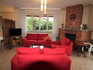 ポルト・ヴァルトラヴァーリアにあるHoliday Home Bramati by Interhomeのリビングルーム(赤いソファ、暖炉付)