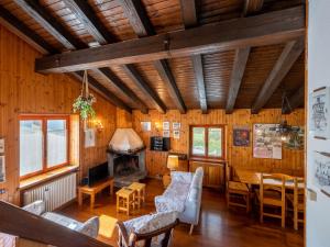 - un salon avec des murs en bois, une table et des chaises dans l'établissement Chalet Sanitate by Interhome, à Leverogne Rochefort