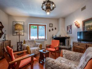 a living room with chairs and a tv and a couch at Chalet Sanitate by Interhome in Leverogne Rochefort