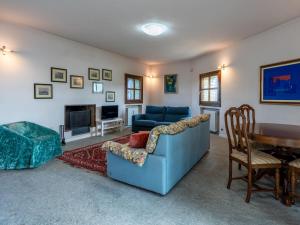 een woonkamer met een blauwe bank en een tafel bij Holiday Home Ca' Sarun by Interhome in Santo Stefano Belbo