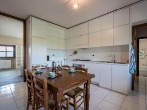 uma cozinha com uma mesa e cadeiras de madeira e um lavatório em Holiday Home Ca' Sarun by Interhome em Santo Stefano Belbo