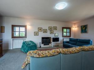 uma sala de estar com um sofá azul e uma lareira em Holiday Home Ca' Sarun by Interhome em Santo Stefano Belbo