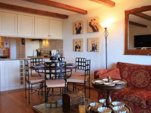 ein Wohnzimmer mit einem Tisch und Stühlen sowie eine Küche in der Unterkunft Apartment Le Bouquetin 1 by Interhome in Villars-sur-Ollon