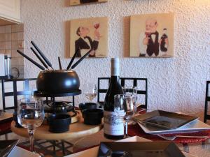 einen Esstisch mit einer Flasche Wein und Weingläsern in der Unterkunft Apartment Le Bouquetin 1 by Interhome in Villars-sur-Ollon