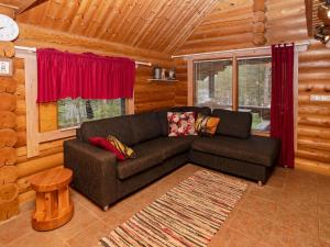 a living room with a couch in a log cabin at Holiday Home Iltatähti by Interhome in Kirpistö