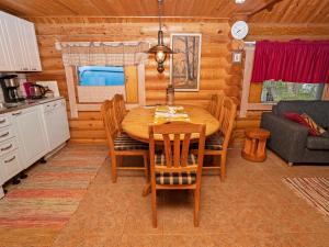 a kitchen and dining room with a wooden table and chairs at Holiday Home Iltatähti by Interhome in Kirpistö