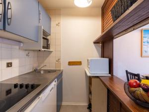una cucina con lavandino e bancone con un cesto di frutta di Apartment Les Tommeuses - Val Claret-9 by Interhome a Tignes