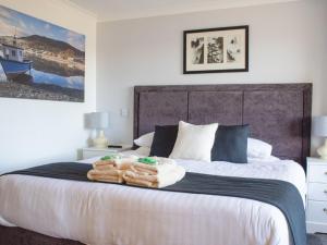 1 dormitorio con 1 cama grande y toallas. en Holiday Home Viewfield by Interhome, en Portree