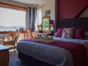 a bedroom with a large bed with towels on it at Holiday Home Viewfield by Interhome in Portree