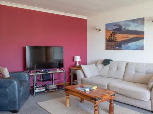 sala de estar con sofá y TV en Holiday Home Viewfield by Interhome, en Portree
