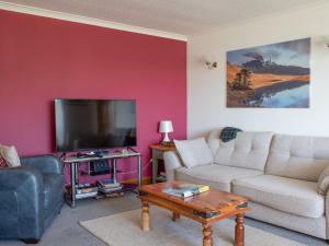 a living room with a couch and a tv at Holiday Home Viewfield by Interhome in Portree