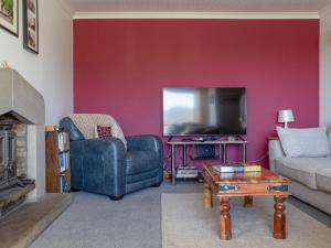 a living room with a couch a chair and a tv at Holiday Home Viewfield by Interhome in Portree