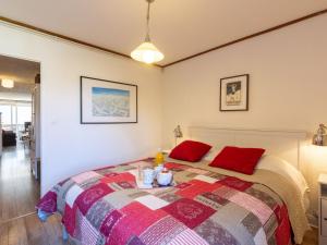 a bedroom with a bed with two red pillows at Apartment Le Pramecou - Val Claret-11 by Interhome in Tignes +19 photos