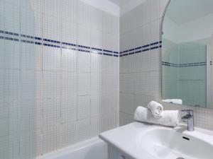 ein Badezimmer mit einer Badewanne, einem Waschbecken und einem Spiegel in der Unterkunft Apartment Rond Point des Pistes-2 by Interhome in Tignes