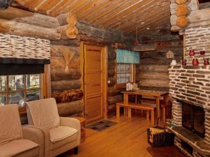 ein Wohnzimmer mit Kamin in einer Blockhütte in der Unterkunft Holiday Home Villihanhi 7b by Interhome in Nissi