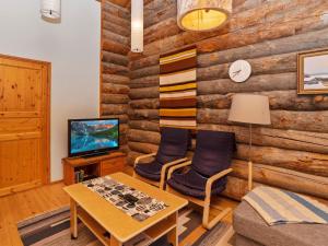 een woonkamer met een houten muur bij Holiday Home Rukankuukkeli a5 by Interhome in Ruka