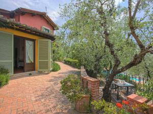 a house with a brick driveway next to a tree at Apartment Borgo della Limonaia-1 by Interhome in Pieve a Nievole