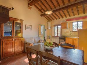 a kitchen and living room with a wooden table and a table at Apartment Campiglia-1 by Interhome in Tavarnelle in Val di Pesa