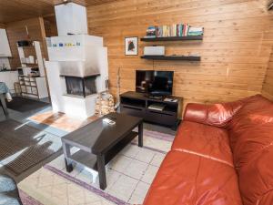 een woonkamer met een leren bank en een televisie bij Holiday Home Rintelä 5a by Interhome in Ruka