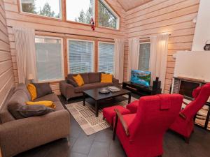 een woonkamer met rode meubels en een open haard bij Holiday Home Vuosselin kataja 5 by Interhome in Ruka