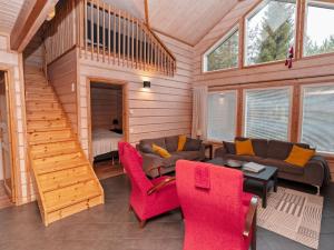 een woonkamer met een bank en rode stoelen bij Holiday Home Vuosselin kataja 5 by Interhome in Ruka