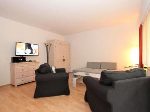 a living room with two chairs and a bed at Apartment Am Birkenhain-2 by Interhome in Seefeld in Tirol