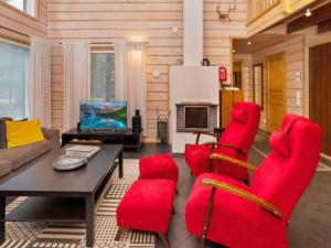 een woonkamer met rode stoelen en een tafel bij Holiday Home Vuosselin kataja 5 by Interhome in Ruka
