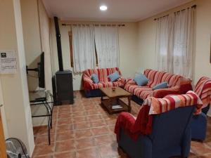 a living room with two couches and a television at Casa Herron in Cazorla