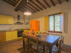 eine Küche mit einem Holztisch mit einer Obstschale darauf in der Unterkunft Apartment Campiglia-5 by Interhome in Tavarnelle in Val di Pesa