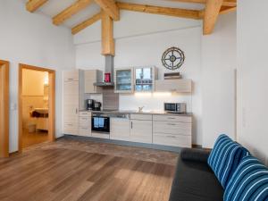 a kitchen with white cabinets and a couch in a room at Apartment Steinernes Meer by Interhome in Saalfelden am Steinernen Meer