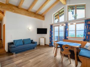 a living room with a blue couch and a table at Apartment Steinernes Meer by Interhome in Saalfelden am Steinernen Meer