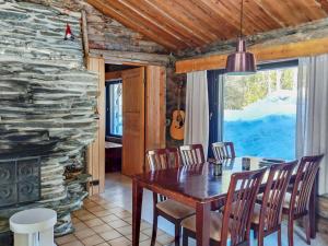 ein Esszimmer mit einem Tisch und einem Steinkamin in der Unterkunft Holiday Home Hallan kelo by Interhome in Ruka