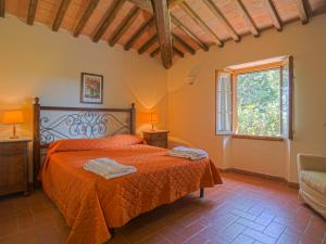 タヴァルネッレ・ヴァル・ディ・ペーザにあるHoliday Home Campiglia-6 by Interhomeのベッドルーム1室(オレンジのシーツが入ったベッド1台、窓付)