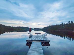 a dock with a table and chairs on a lake at Holiday Home Hallan kelo by Interhome in Ruka