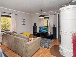 a living room with a couch and a television at Holiday Home Vuorimäki by Interhome in Ruka