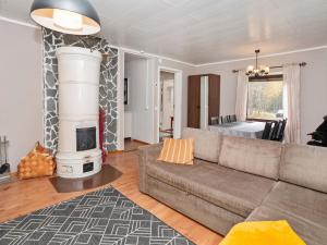 ein Wohnzimmer mit Couch und Kamin in der Unterkunft Holiday Home Vuorimäki by Interhome in Ruka