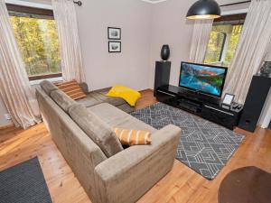 a living room with a couch and a flat screen tv at Holiday Home Vuorimäki by Interhome in Ruka