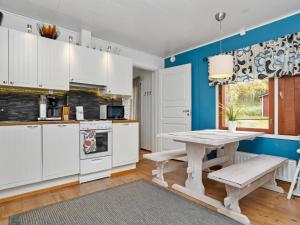 eine Küche mit weißen Schränken und einem Tisch in der Unterkunft Holiday Home Vuorimäki by Interhome in Ruka + 14 Fotos