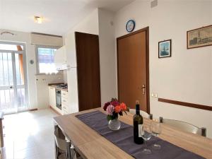 una cocina con una mesa con botellas de vino y flores en Apartment Palazzeta IV by Interhome, en La Cinquantina