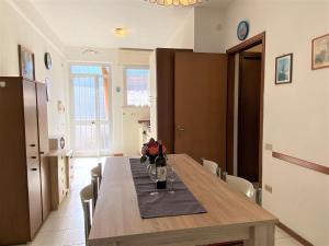 Una mesa de comedor con un jarrón de flores encima. en Apartment Palazzeta IV by Interhome, en La Cinquantina