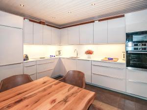 a kitchen with white cabinets and a wooden table at Holiday Home Arctic chalet by Interhome in Ylläsjärvi