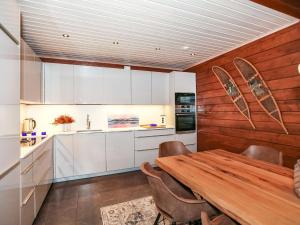 ユッラスヤルヴィにあるHoliday Home Arctic chalet by Interhomeの白いキャビネットと木製テーブル付きのキッチン