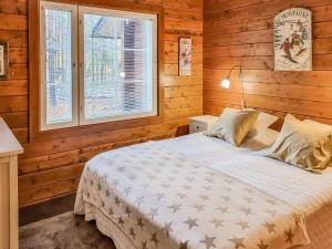 a bedroom with a bed in a wooden room at Holiday Home Arctic chalet by Interhome in Ylläsjärvi +16 photos